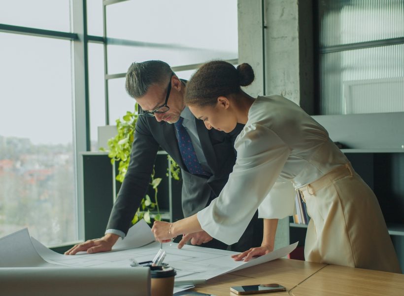 Architects discussing floor plan in modern office
